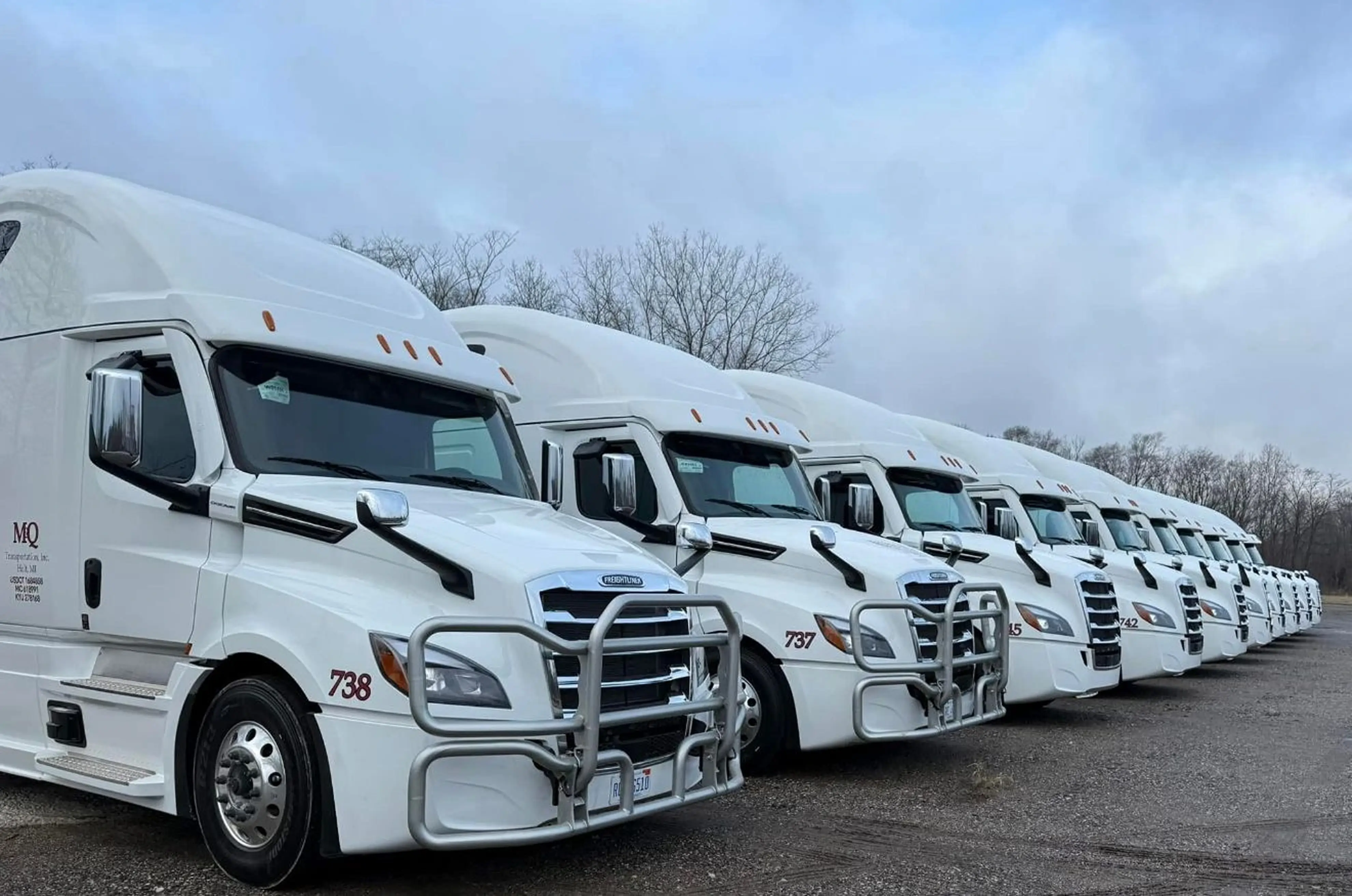 Row of M&Q semi-trucks ready for dispatch